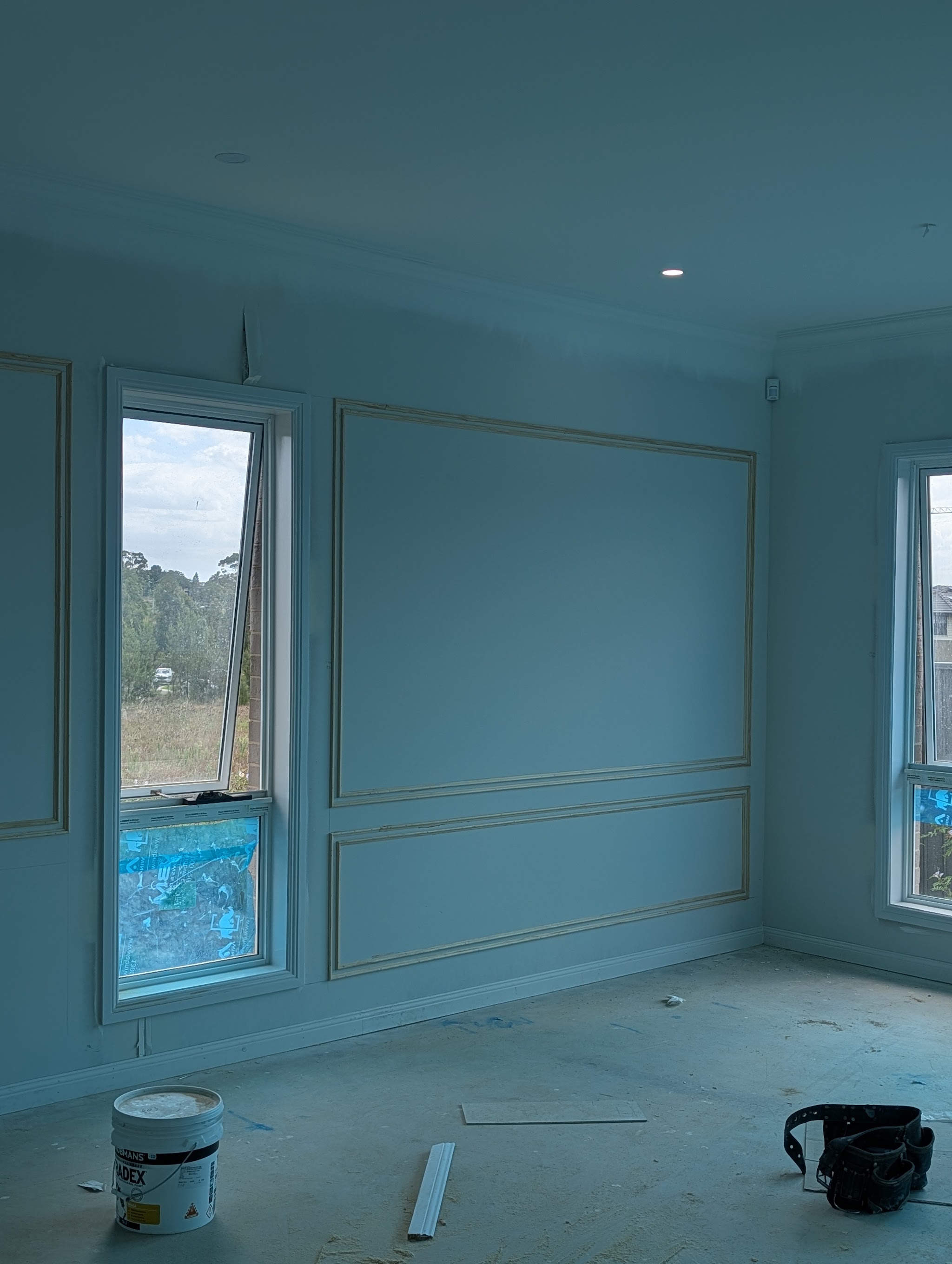 Wall moulding panels fixed in a large room, primed and ready for paint